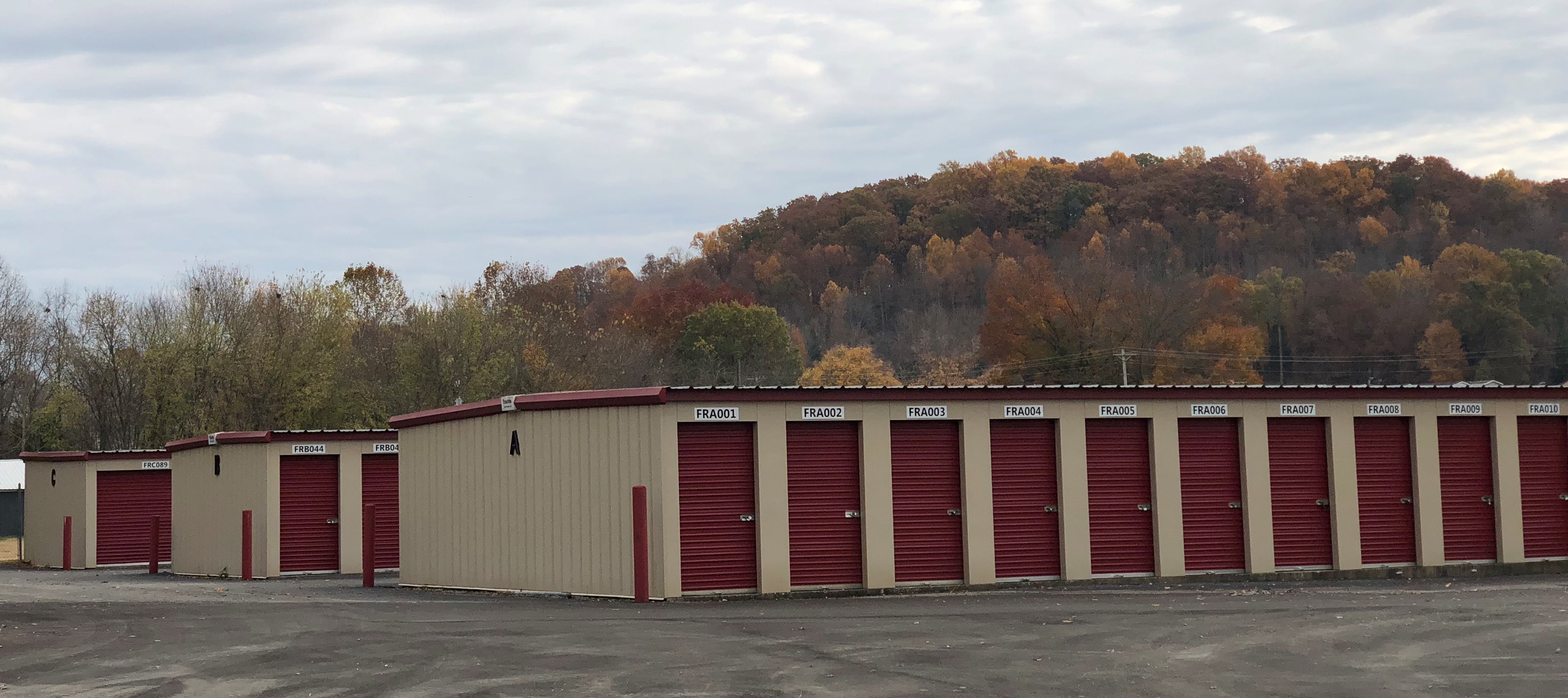 Drive-up storage units with vibrant red doors, offering easy access and secure storage at Access Storage facility.